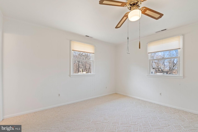 spare room featuring a healthy amount of sunlight, carpet, and visible vents