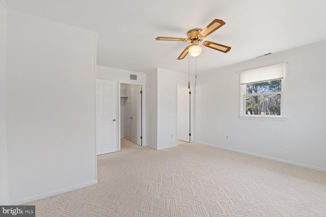 spare room with light carpet, baseboards, visible vents, and a ceiling fan