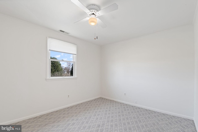 carpeted empty room featuring visible vents, ceiling fan, and baseboards