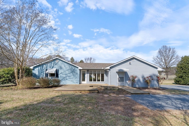 ranch-style home with a front lawn and a wooden deck