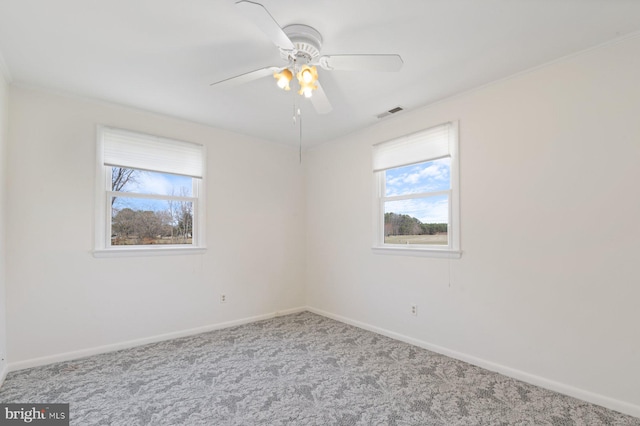 unfurnished room with visible vents, carpet, a ceiling fan, and baseboards