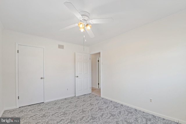 unfurnished bedroom featuring a ceiling fan, carpet flooring, visible vents, and baseboards