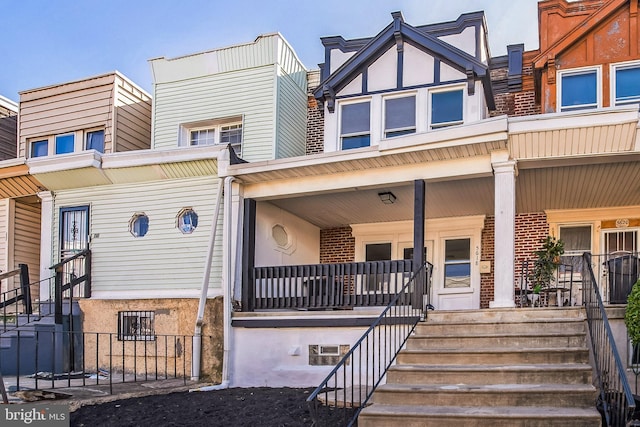 multi unit property with brick siding and a porch