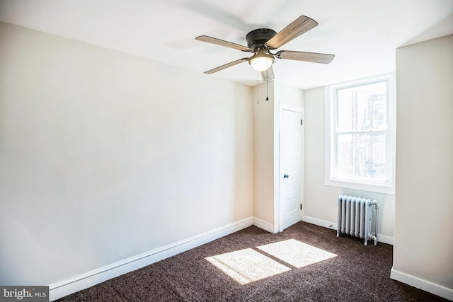 unfurnished bedroom featuring dark colored carpet, baseboards, and radiator