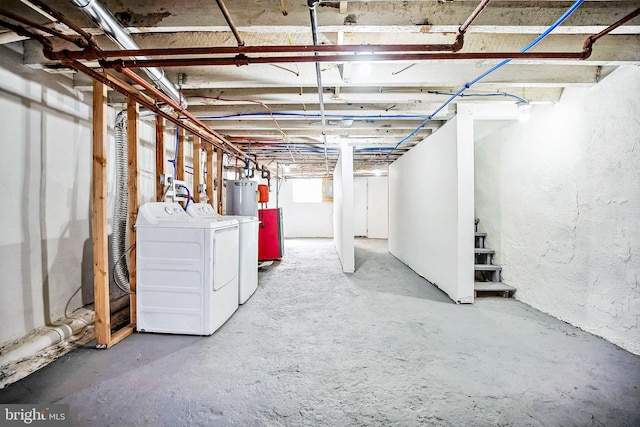 below grade area featuring water heater and washing machine and clothes dryer