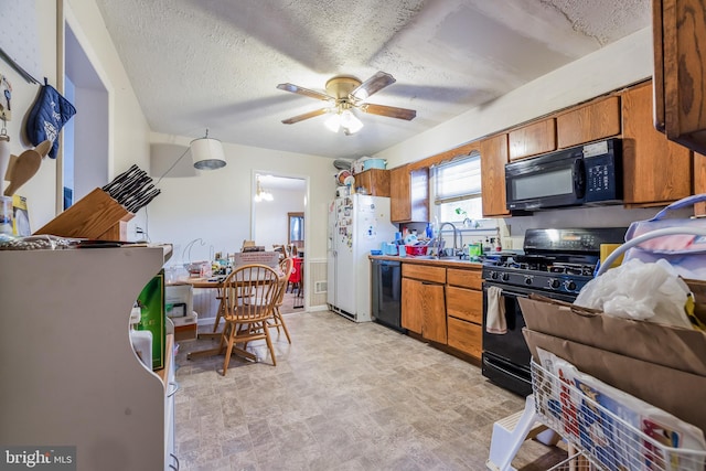 kitchen featuring brown cabinetry, ceiling fan, a textured ceiling, and black appliances