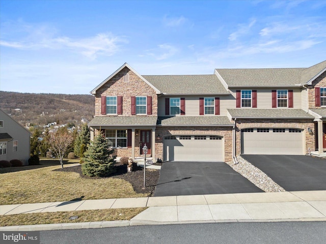 view of front of house featuring aphalt driveway, stone siding, an attached garage, and a shingled roof