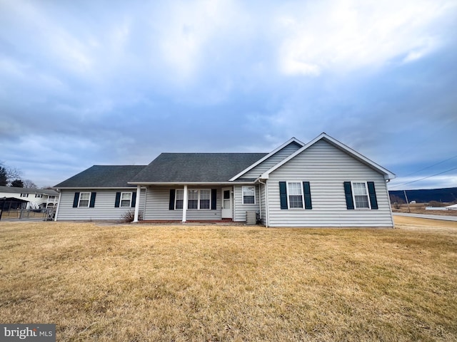 view of front facade featuring roof with shingles and a front lawn