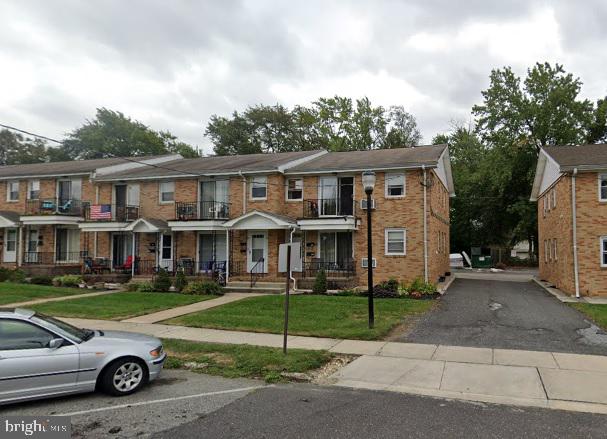 multi unit property featuring brick siding and a front yard