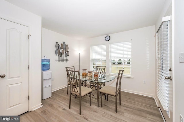 dining area with light wood-style floors and baseboards