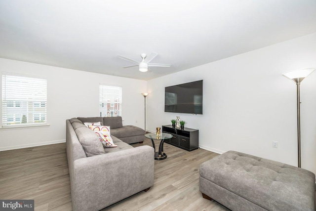 living room featuring ceiling fan, baseboards, and wood finished floors