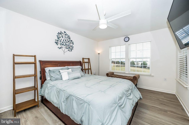 bedroom featuring wood finished floors, a ceiling fan, and baseboards