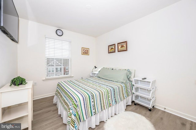 bedroom featuring baseboards and wood finished floors