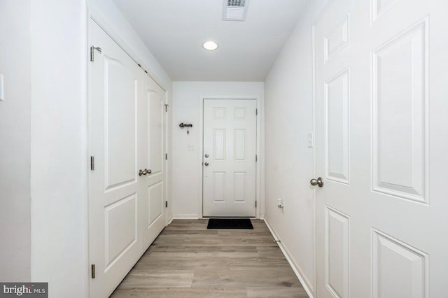 doorway with light wood-style floors, recessed lighting, visible vents, and baseboards