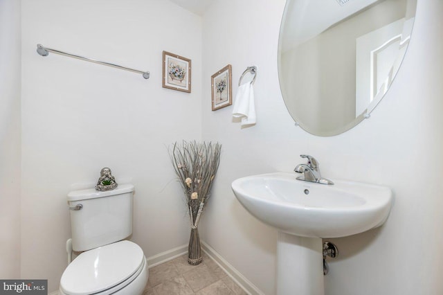 bathroom featuring toilet and baseboards