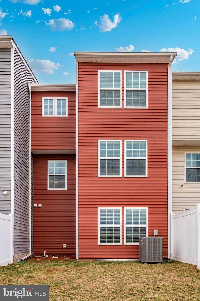 back of house featuring a yard, fence, and central air condition unit