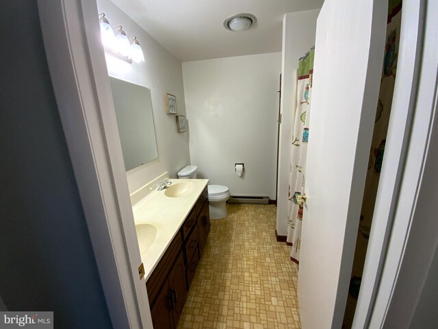 13176 Gearhart Rd, Greencastle, PA 17225 - bathroom with a sink, double vanity, a baseboard heating unit, toilet, and tile patterned floors