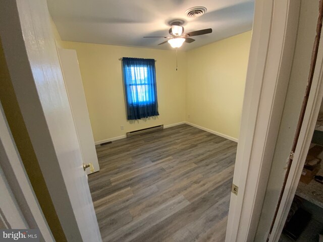 13176 Gearhart Rd, Greencastle, PA 17225 - spare room featuring dark wood-style flooring, ceiling fan, visible vents, baseboards, and baseboard heating