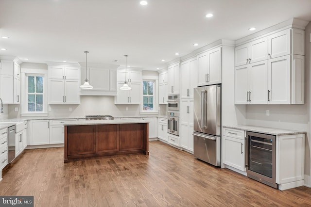 kitchen featuring wine cooler, appliances with stainless steel finishes, white cabinets, and a healthy amount of sunlight