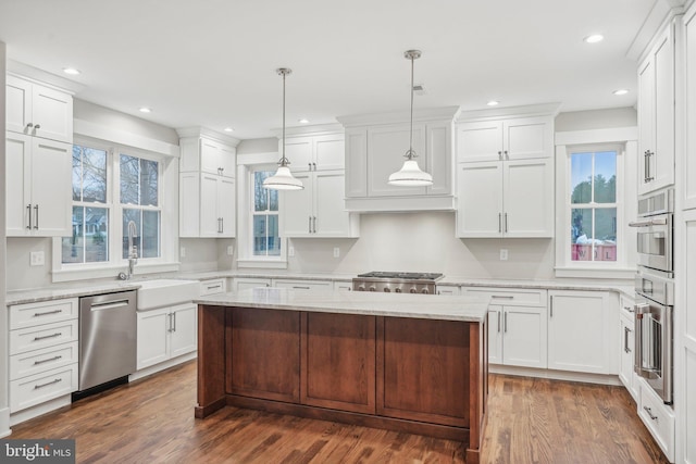 kitchen featuring dishwasher, white cabinets, plenty of natural light, and a sink