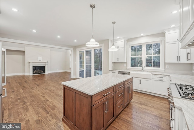 kitchen featuring white cabinetry, light wood-type flooring, and light stone countertops