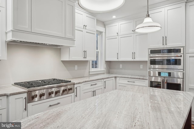 kitchen featuring decorative light fixtures, appliances with stainless steel finishes, and white cabinets