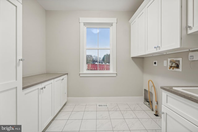 laundry room with electric dryer hookup, visible vents, washer hookup, cabinet space, and baseboards