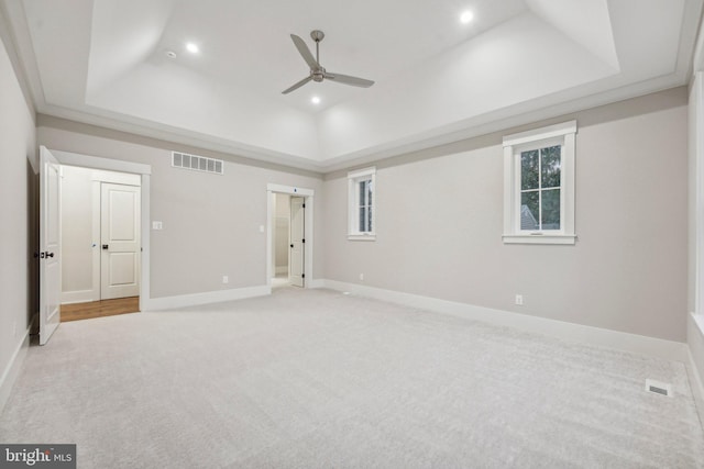 unfurnished bedroom featuring recessed lighting, visible vents, a raised ceiling, and carpet flooring