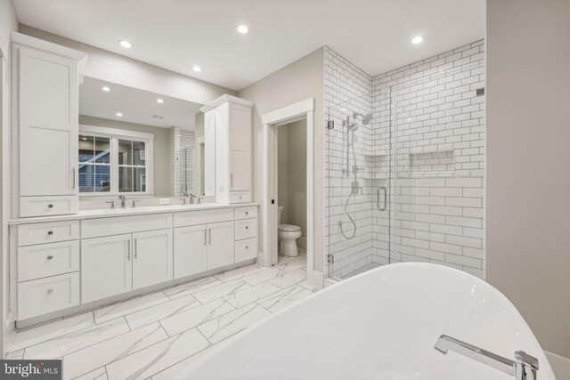 bathroom with a shower stall, toilet, a soaking tub, marble finish floor, and a sink