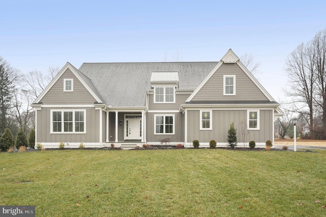 view of front facade featuring board and batten siding, a shingled roof, and a front lawn