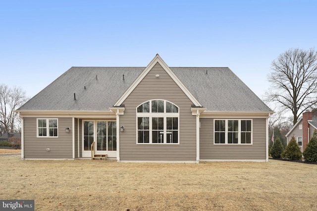 rear view of house with a lawn and a shingled roof