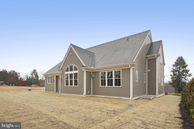 back of property featuring a shingled roof