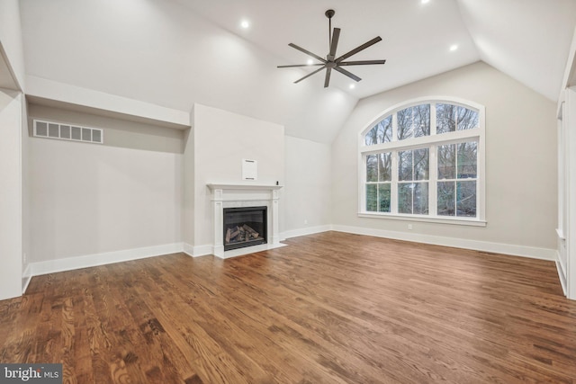 unfurnished living room featuring visible vents, a fireplace with flush hearth, vaulted ceiling, wood finished floors, and a ceiling fan