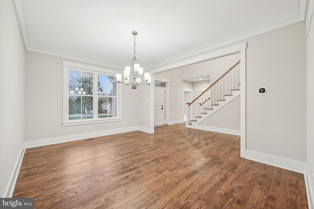 unfurnished dining area with stairway, wood finished floors, baseboards, and ornamental molding