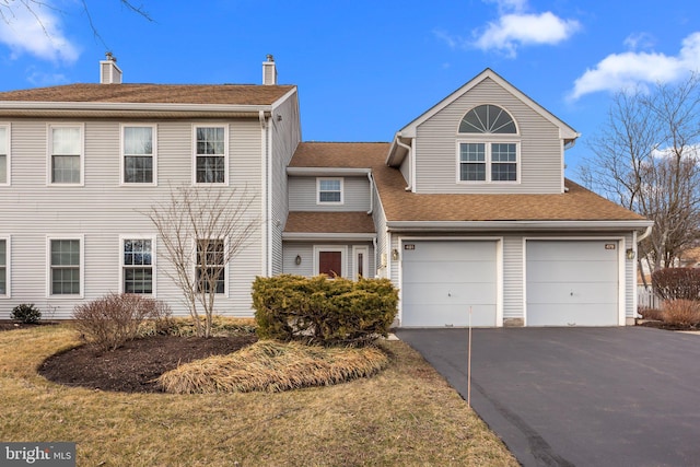 view of front of house featuring a garage, aphalt driveway, and roof with shingles