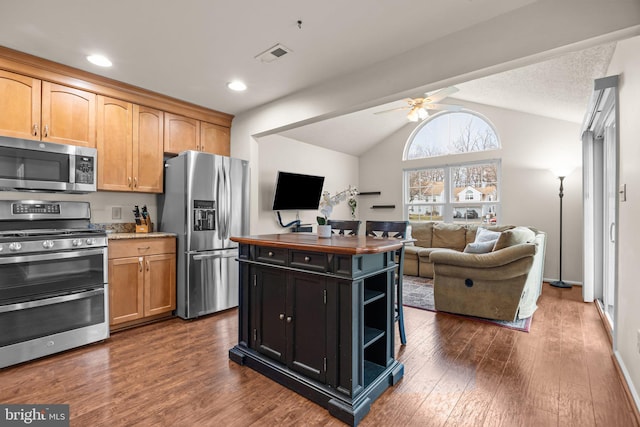 kitchen featuring visible vents, stainless steel appliances, dark wood finished floors, and open floor plan