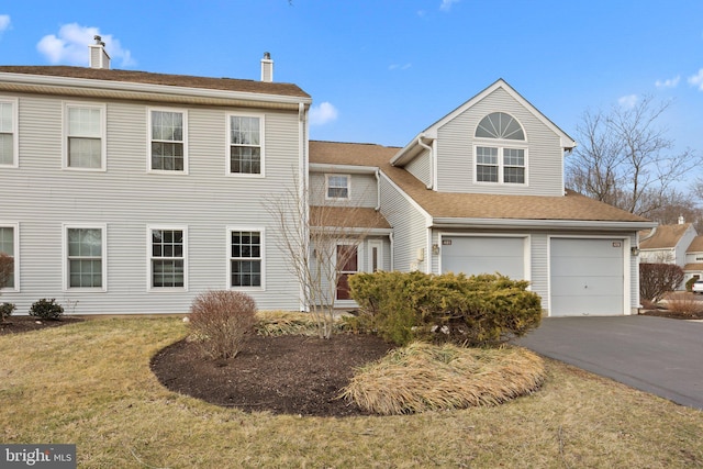 view of front of property with an attached garage, aphalt driveway, and a front yard