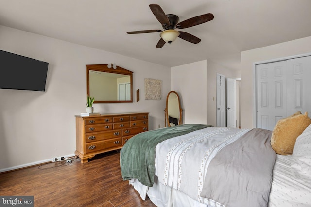 bedroom with dark wood-style floors, a closet, baseboards, and a ceiling fan