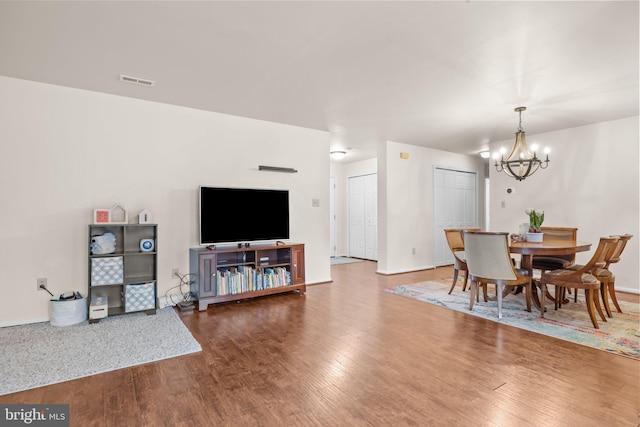 dining room with baseboards, visible vents, an inviting chandelier, and wood finished floors