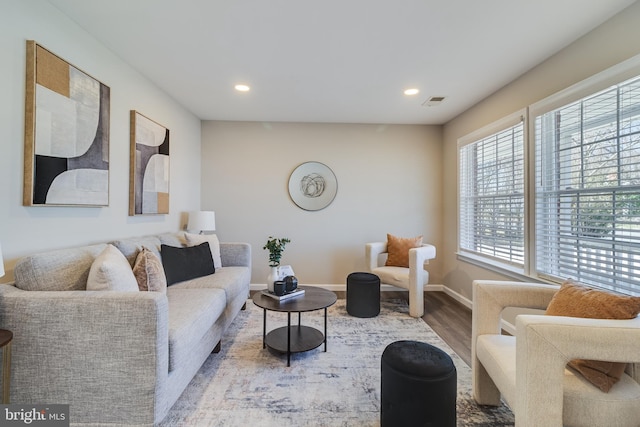 living area with recessed lighting, visible vents, baseboards, and wood finished floors