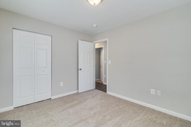 unfurnished bedroom featuring a closet, baseboards, and carpet