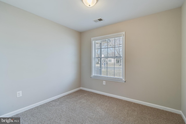 carpeted spare room featuring visible vents and baseboards