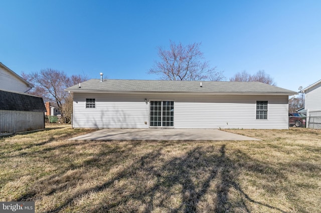 back of property with a yard, a patio, and fence