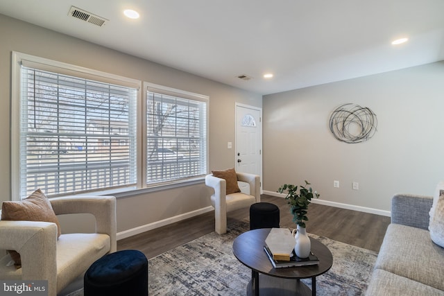 living room with recessed lighting, wood finished floors, and visible vents