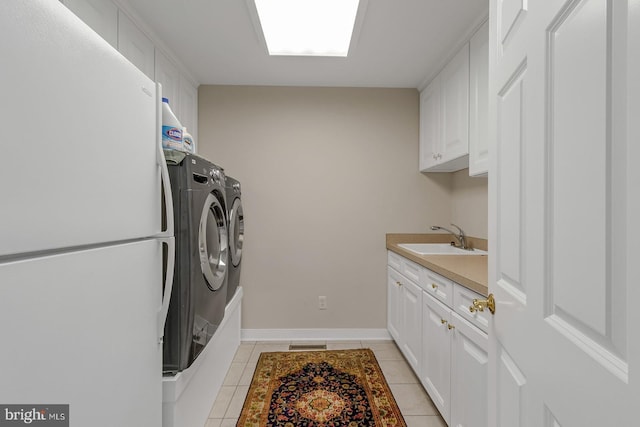 laundry area featuring light tile patterned floors, cabinet space, visible vents, a sink, and independent washer and dryer