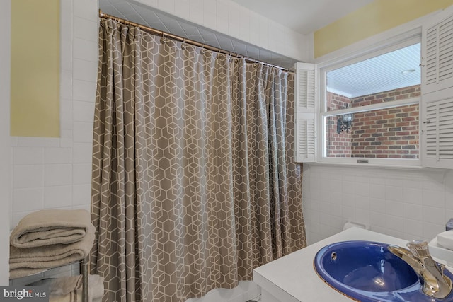 bathroom featuring a sink, tile walls, and a shower with curtain