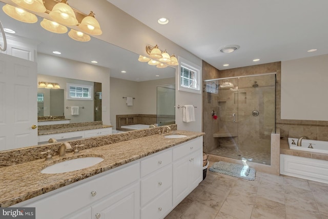 bathroom with double vanity, a sink, a shower stall, and a bath