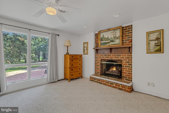 carpeted living room featuring a brick fireplace, ceiling fan, and baseboards