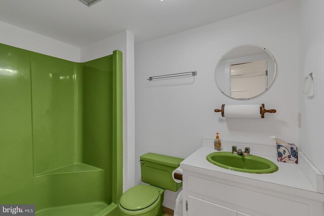 bathroom with a shower, vanity, and toilet