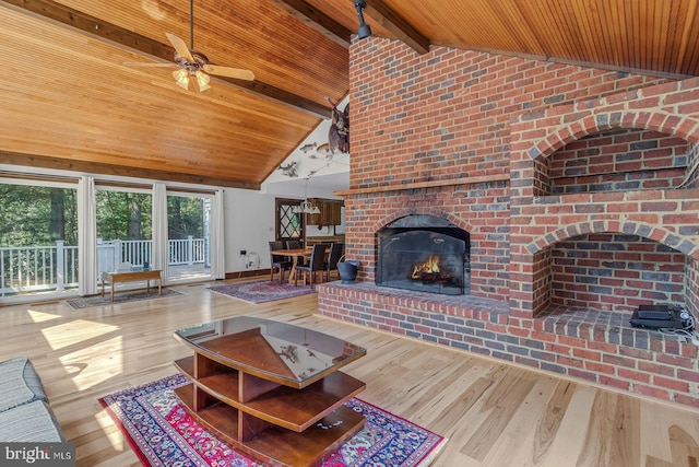 living room featuring wooden ceiling, a brick fireplace, wood-type flooring, and beam ceiling